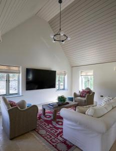 a living room with two couches and a flat screen tv at Stunning Cotswolds guest house in Chadlington