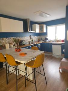 a kitchen with a table and chairs in a room at Chambre Cosy chez l'habitant - parking - spa -terrasse in Saint-Alban