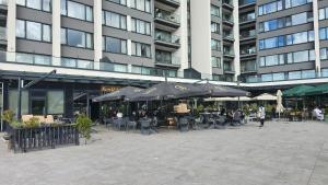 a courtyard with tables and umbrellas in front of a building at Apartment Lana in Sarajevo