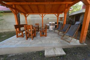 a wooden pergola with chairs and a table on a patio at U starej mamy - ubytovanie na Tokaji in Malá Tŕňa