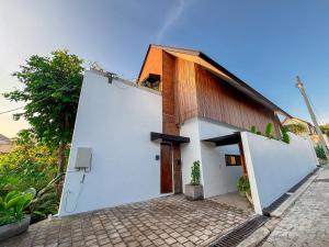 une petite maison blanche avec un toit marron dans l'établissement Uma Ugeng Cemagi 2 BR, à Cemagi