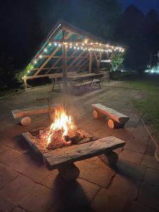 eine Feuerstelle mit Bänken in einem Park in der Nacht in der Unterkunft Leśny Zakątek in Augustów
