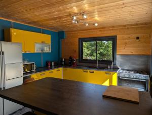 une cuisine avec des armoires jaunes et une table à l'intérieur dans l'établissement Villa Mammouth, à Saint Alban Auriolles