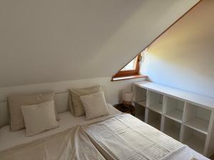 a bed with white pillows and a window in a room at Studio Lilly in Bohinj