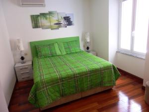 una camera con un letto verde e un piumone verde di Apartment Pula Center a Pola (Pula)