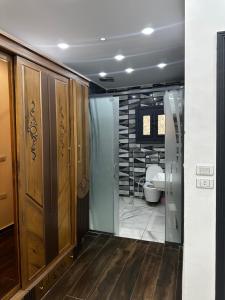 a bathroom with a toilet and a glass door at villa 578 in Sheikh Zayed