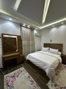 a bedroom with a large white bed and a window at villa 578 in Sheikh Zayed