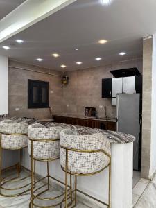 a kitchen with a counter with bar stools at villa 578 in Sheikh Zayed