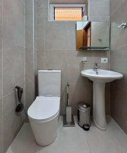 a bathroom with a toilet and a sink at Graci Apartments in Sarandë +31 photos