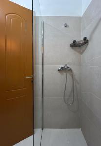 a bathroom with a shower with a glass door at Graci Apartments in Sarandë