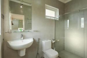 a bathroom with a sink and a toilet and a mirror at Shalom Residence Kandy in Kandy +30 photos