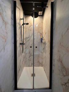 a bathroom with a shower with a glass door at Cozy Family Apartment - Bus & Tram Right in Front in Antwerp +2 photos
