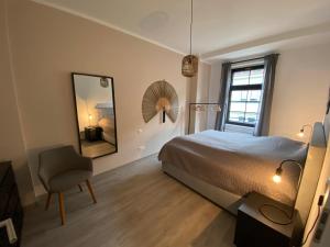 a bedroom with a bed and a mirror and a chair at discovAVIR - Super Zentral mit Parkplatz, Küche, Netflix und mehr in Eisenach