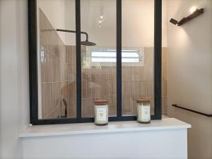 two candles sitting on a window sill in a bathroom at La petite villa in Le Gosier