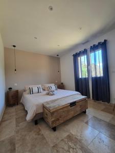 a bedroom with a large bed with blue curtains at Domaine U Filanciu - Centru di Corsica in Moltifao +10 photos