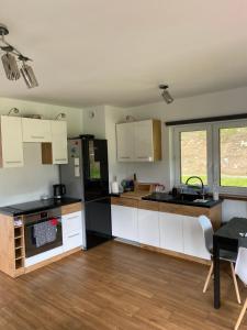 a kitchen with white cabinets and a black refrigerator at Arkadia pod Diablakiem in Zawoja