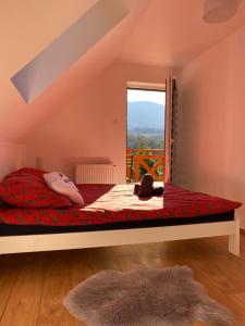 a bedroom with a large bed with a window at Arkadia pod Diablakiem in Zawoja