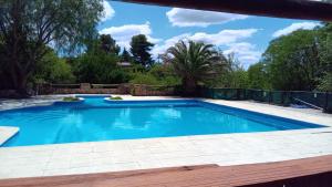 a swimming pool in a backyard with a fence and trees at APART HOTEl ACUARELA in Mina Clavero