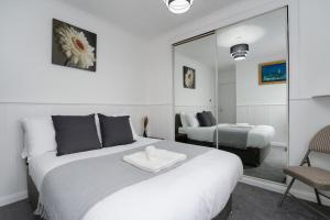 a bedroom with a large white bed and a mirror at 2-Bed Flat Wishaw Free Parking Family-Friendly in Wishaw