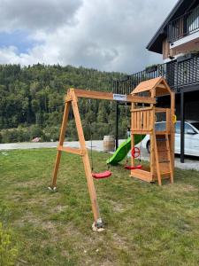 a wooden playground with a slide and a play structure at Elements Chopok in Bystrá
