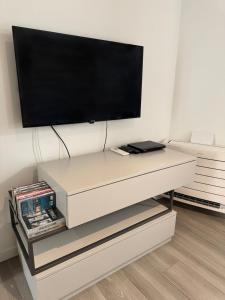 a white entertainment center with a flat screen tv on a wall at ApartBergamo in Bergamo