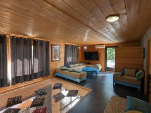 a living room with couches and a tv in a house at Villa Mammouth in Saint Alban Auriolles