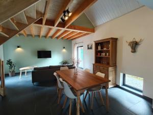a living room with a wooden table and a couch at De kleine Bossenare in Maarkedal