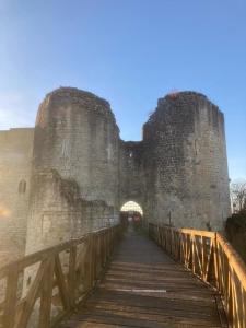 eine Brücke, die zu einem großen Schloss mit einem Gebäude führt in der Unterkunft Le Cocon Châtelain in Gençay + 3 Fotos