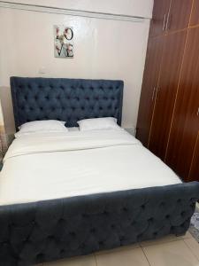 a bed with a blue headboard in a room at Nkubu Homes in Nkubu