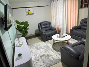 a living room with leather chairs and a table at Nkubu Homes in Nkubu