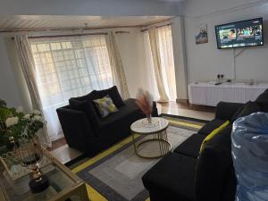 a living room with two couches and a table at Nkubu Homes in Nkubu