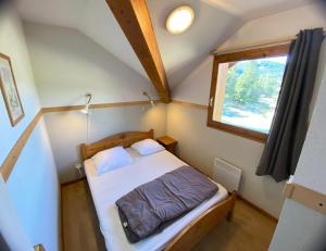 a small bedroom with a bed and a window at Les Chalets De Superd Bleuet - APPARTEMENT 4 PIECES 8 PERSONNES EXPO SUD MAE-8824 in Le Dévoluy