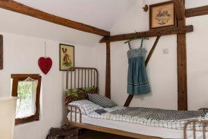 a bedroom with a bed and a dress hanging on the wall at Dom Przytulisko in Janowiec