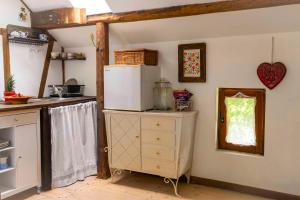 a kitchen with a refrigerator on top of a dresser at Dom Przytulisko in Janowiec