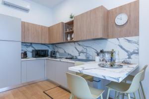 a kitchen with a table with chairs and a clock on the wall at Dimora delle Vittorie - Vaticano in Rome