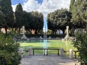 a fountain in a park with green water and trees at Dimora delle Vittorie - Vaticano in Rome