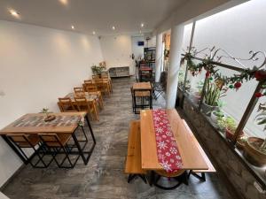 a restaurant with wooden tables and chairs in a room at El Huerto Hostel in Ica