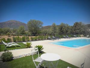 a pool with chairs and a table and a table and chairs at Domaine U Filanciu - Centru di Corsica in Moltifao