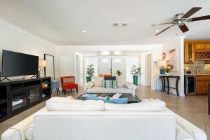 a living room with a white couch and a flat screen tv at Villa LaQuinta Free Pool Heating RV Parking at Point Happy in La Quinta