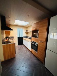 a kitchen with wooden cabinets and a stove top oven at Gîte du Phare in Grand-Fort-Philippe +2 photos
