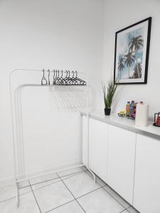 a white kitchen with white cabinets and a shelf at Mila's Cosy Place in Boortmeerbeek