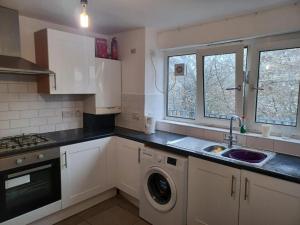 a kitchen with a sink and a washing machine at Extra Large Room Near Stratford Station in London +6 photos