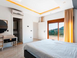 une chambre avec un grand lit et une grande fenêtre dans l'établissement Alanya Luxury Villas 1, à Alanya