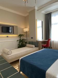 Un dormitorio con una cama, un sofá y un televisor. en Emily Taksim Hotel, en Estambul