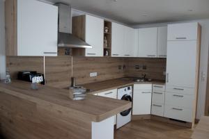 a kitchen with white cabinets and a wooden counter top at Ankerplatz35 in Carolinensiel +4 photos