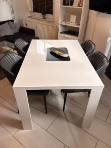 ein weißer Tisch in einem Wohnzimmer mit Stühlen in der Unterkunft Waldzeit Braunlage - WLAN - Parkplatz - Terrasse - ebenerdig in Braunlage + 6 Fotos