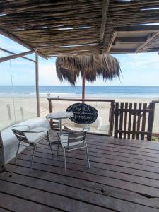 a patio with a table and chairs on the beach at Mancora Apartments in Máncora