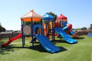 a playground with several slides at LuxChalet Ferienhaus ELLA mit Aussicht auf die Ijssel im Ferienpark mit Pool und Strand Holland Niederlande in Lathum