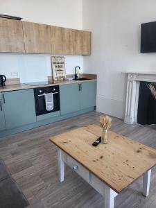 a kitchen with a wooden table in a room at Seaview Charm Herne Bay in Herne Bay