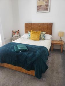 a bedroom with a large bed with a blue blanket at Seaview Charm Herne Bay in Herne Bay